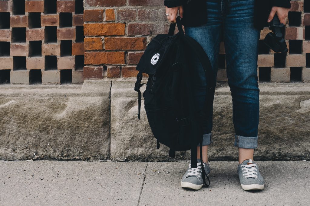 A person standing holding a black bag