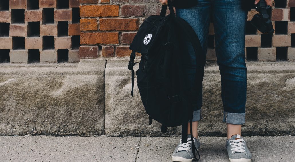 A person standing holding a black bag