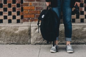 A person standing holding a black bag