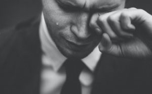 Man wiping his tears