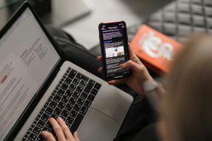 A person using both laptop and phone