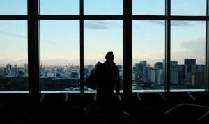 Silhouette of a person looking to a glass window