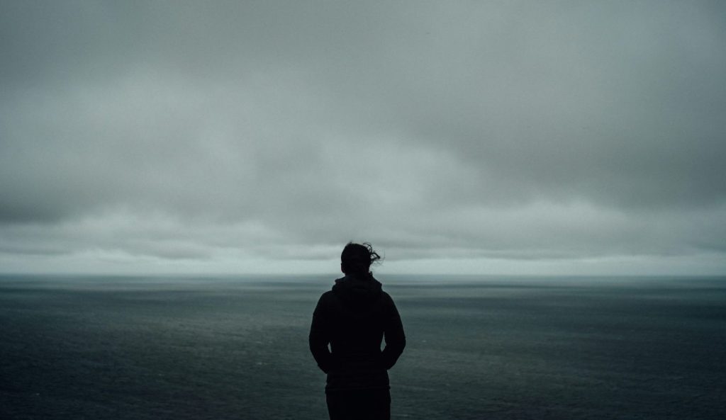 A person standing in front of an ocean