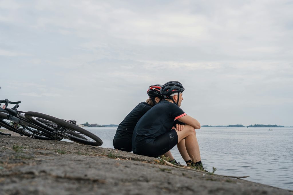 Two bikers sitting on the seashore