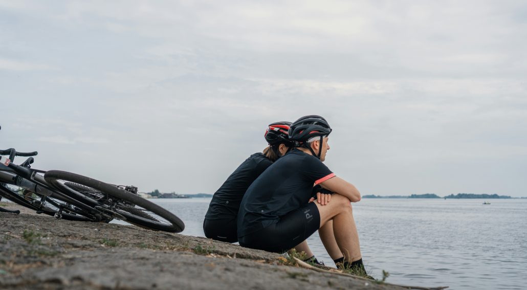 Two bikers sitting on the seashore