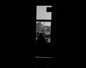 silhouette of a man staring outside the window