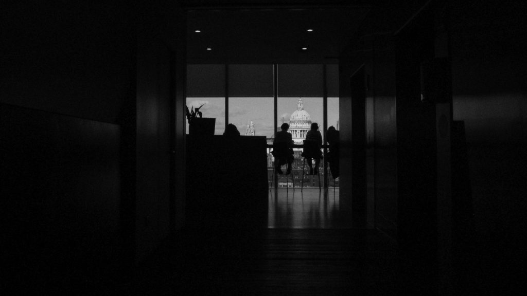Silhouette of people sitting in a room with an overlooking view