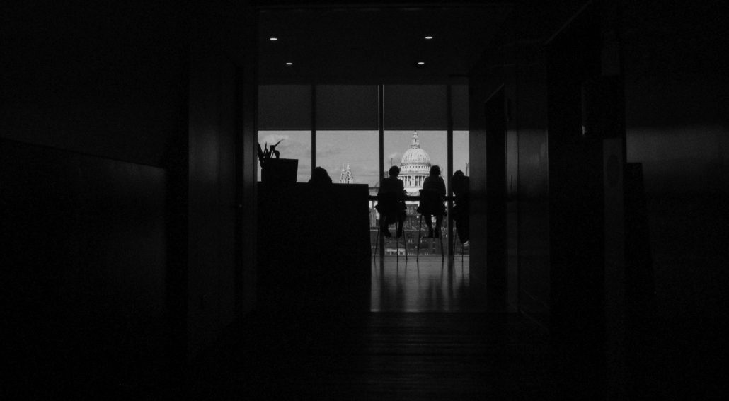 Silhouette of people sitting in a room with an overlooking view