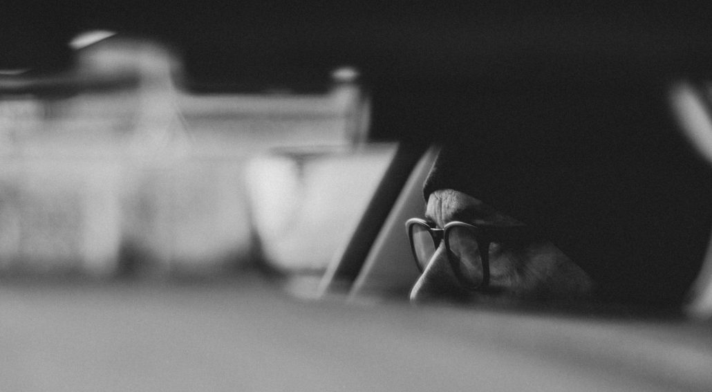 Partial view of a person’s face in a car, captured through a blurred foreground