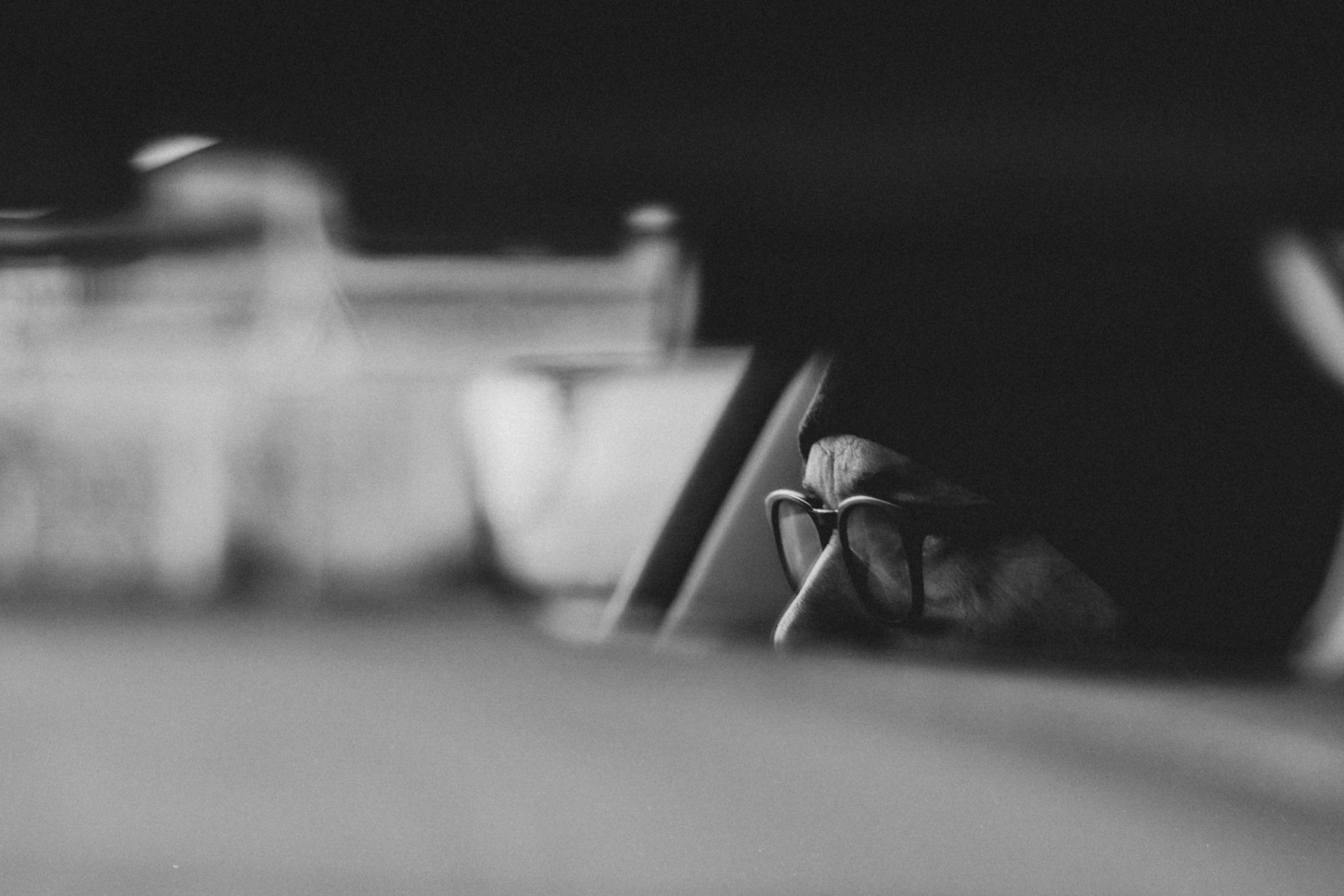 Partial view of a person’s face in a car, captured through a blurred foreground