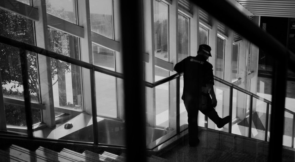 Person standing on a staircase near large windows