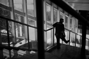 Person standing on a staircase near large windows