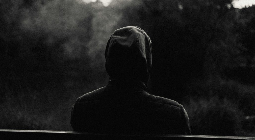 Silhouette of a man sitting on a bench