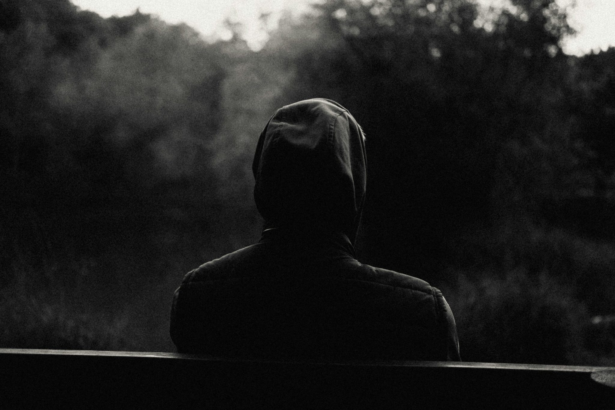 Silhouette of a man sitting on a bench