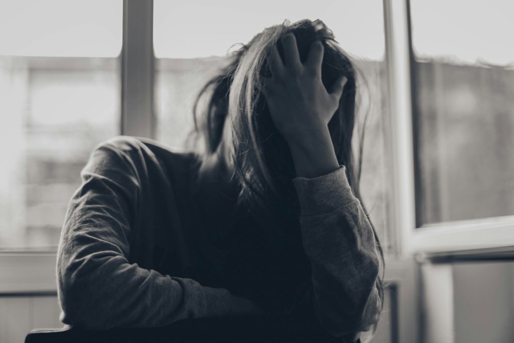 Black and white photo of a woman with one hand covering her face