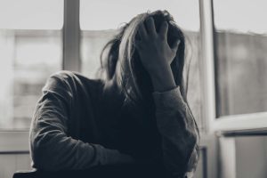Black and white photo of a woman with one hand covering her face