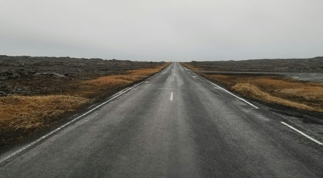 A long, empty road stretching into the distance on a cloudy day