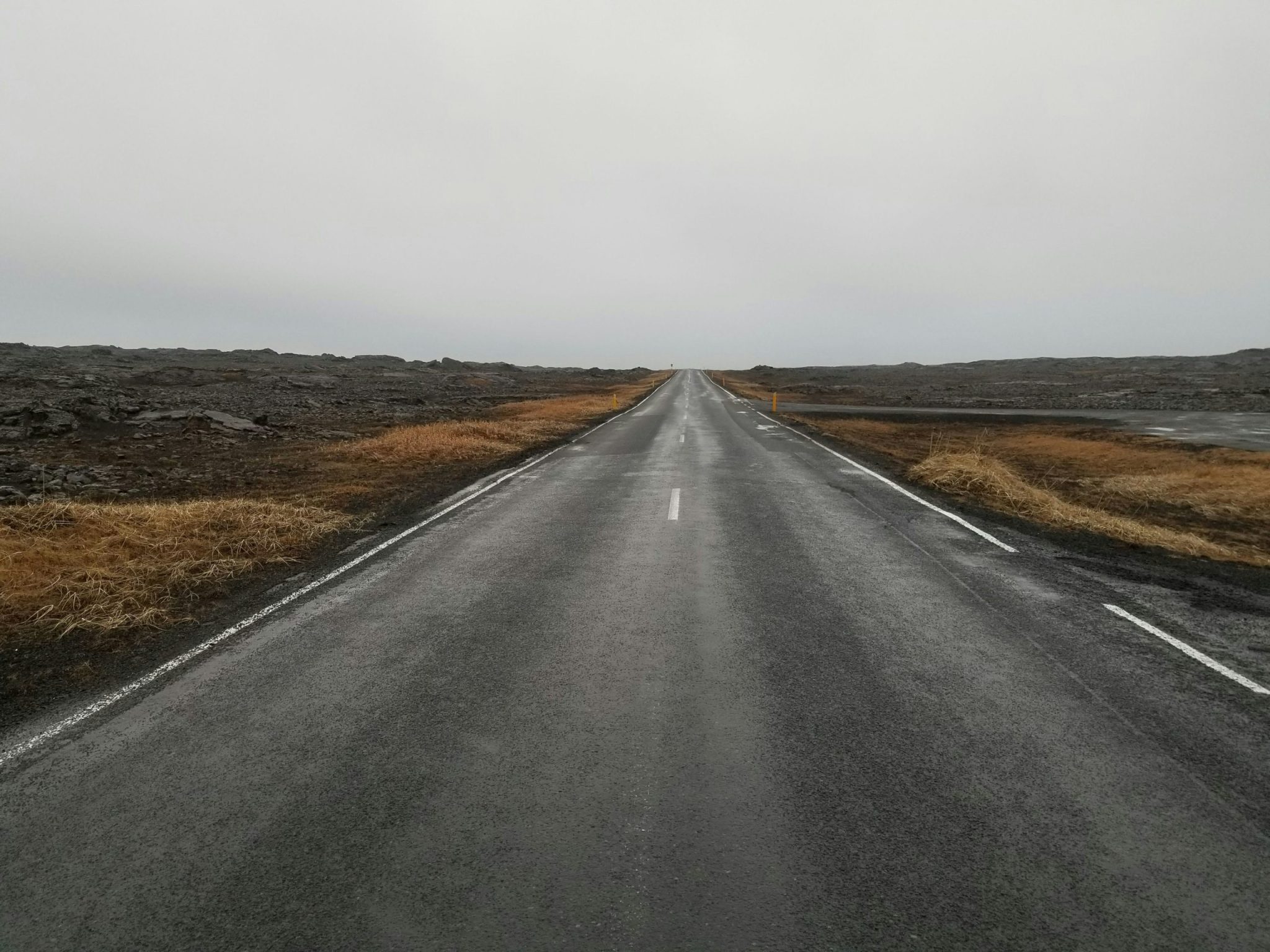 A long, empty road stretching into the distance on a cloudy day