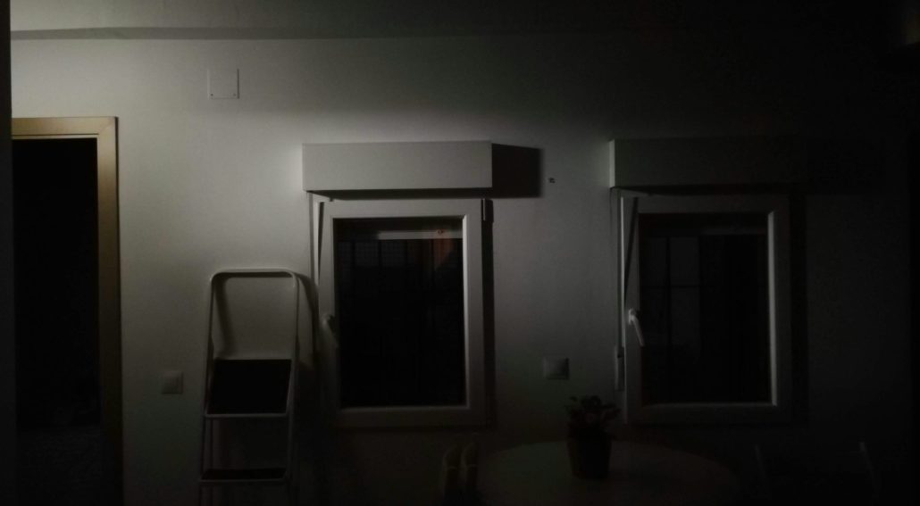 Dimly lit room with two windows and a small table