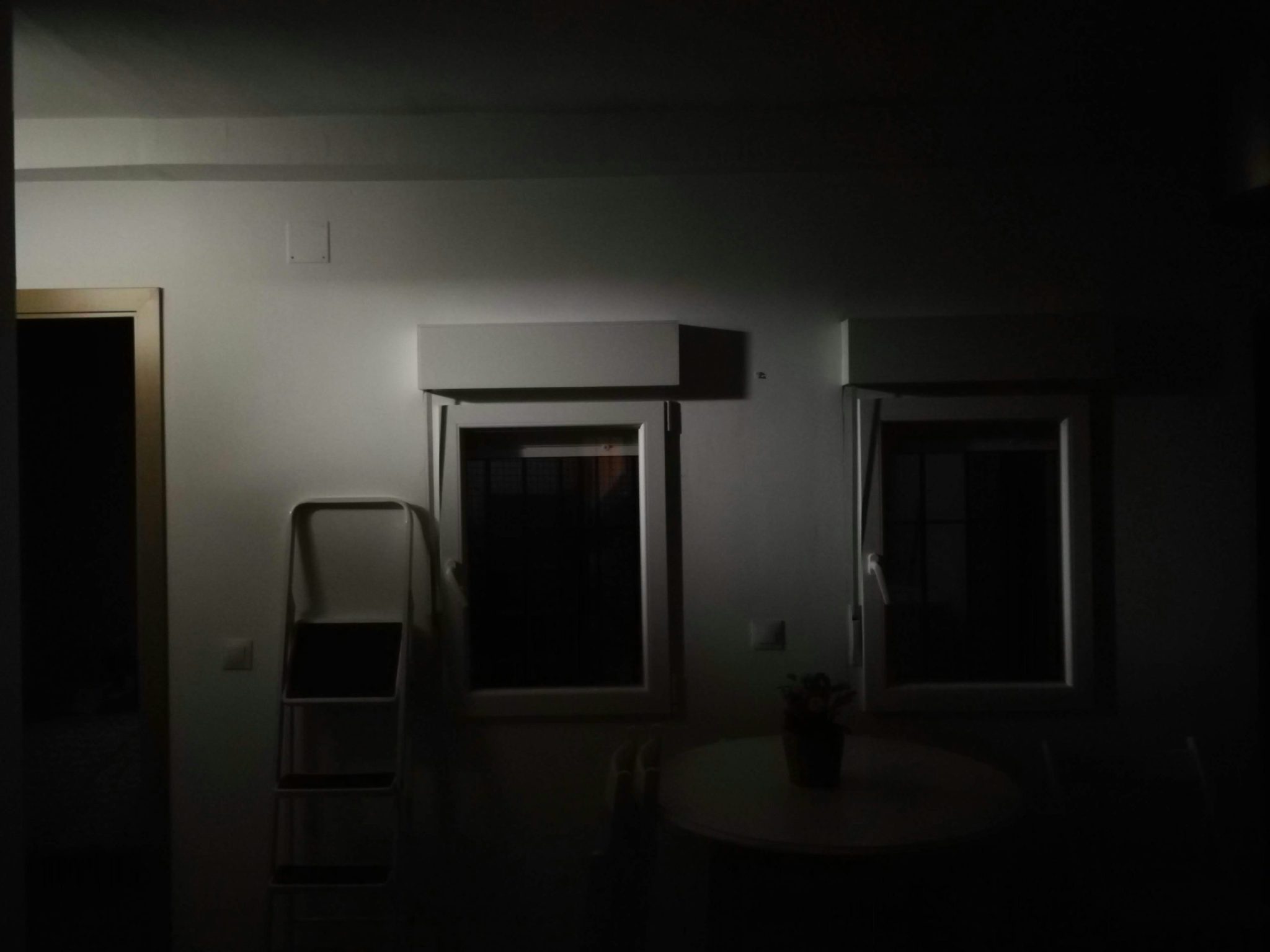 Dimly lit room with two windows and a small table
