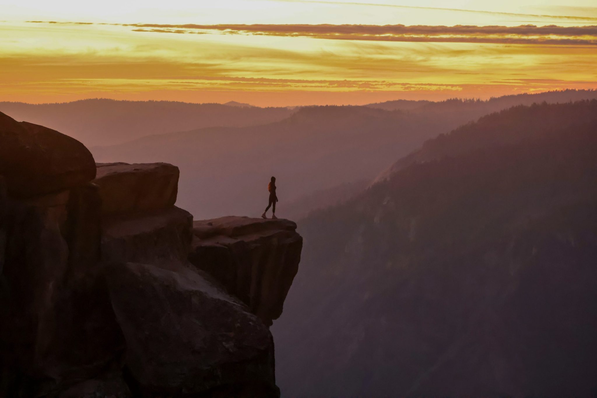 A person standing on the edge of a cliff at daytime