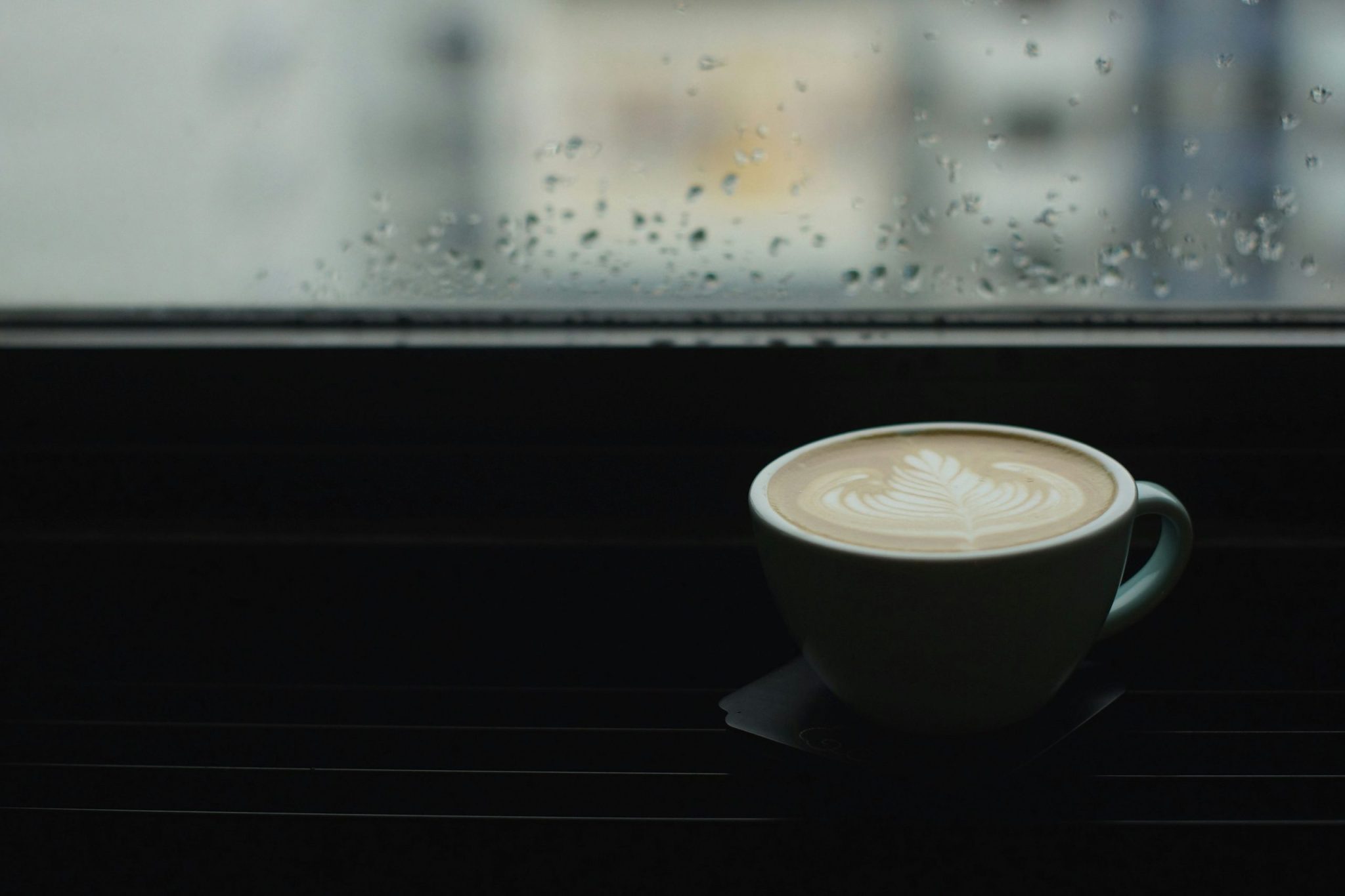 Ceramic cup with coffee on saucer on a table by the window