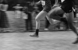 Black and white photo of runners in motion with a blurred background