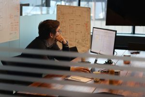 A man in black shirt working on a computer inside an office