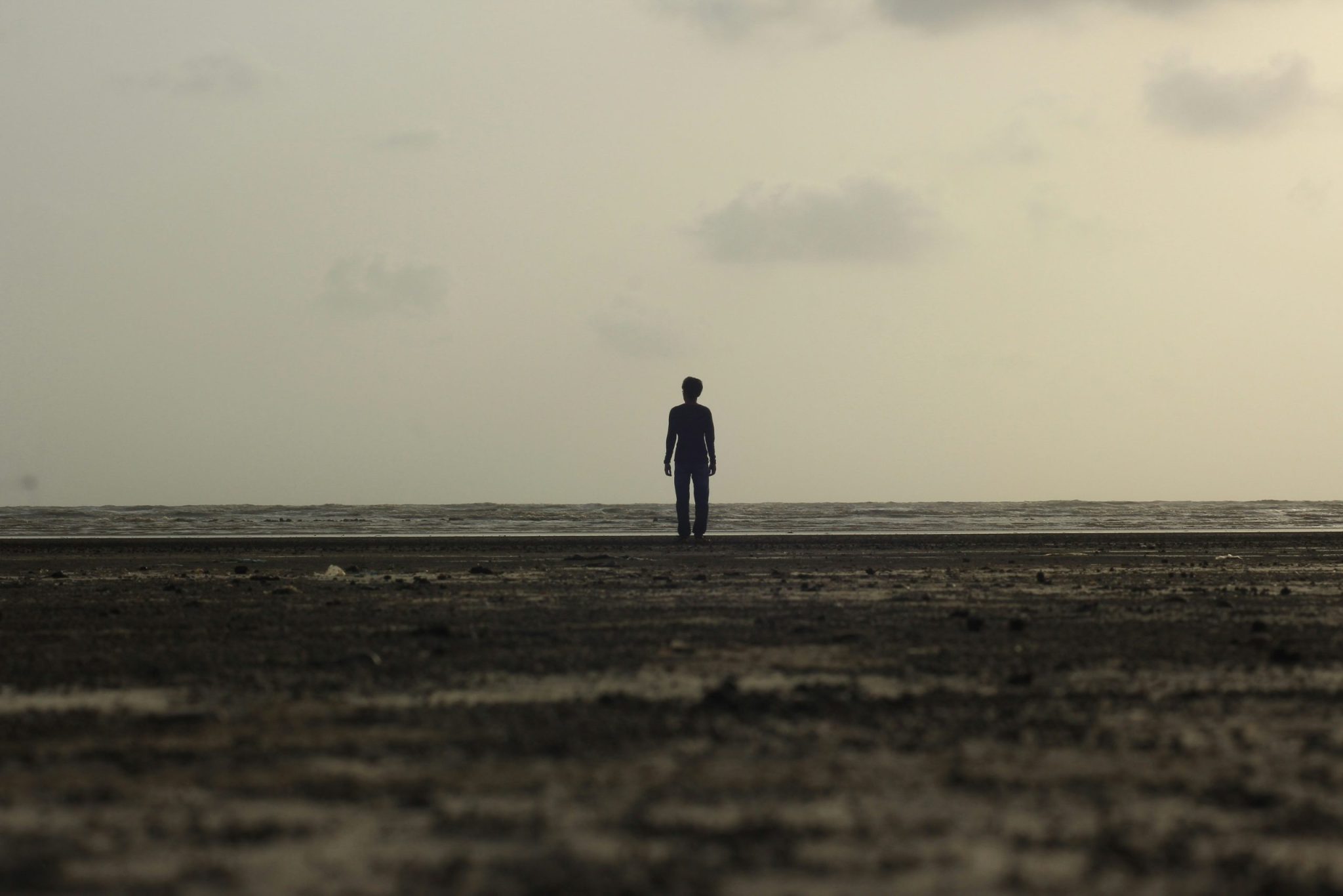Silhouette of a man standing on seashore